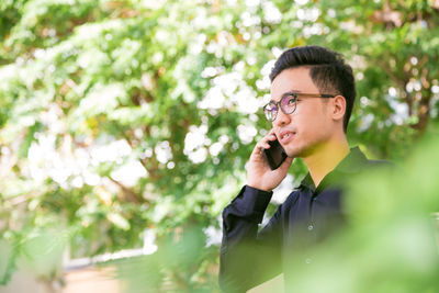 Young man using mobile phone outdoors