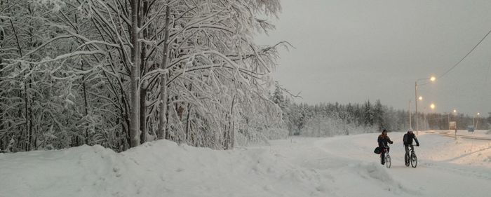 People walking on snow covered landscape