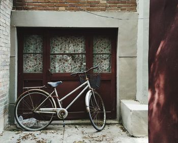 Bicycle leaning on wall of abandoned building