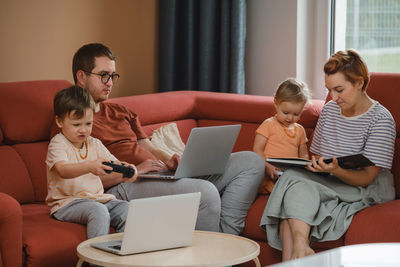 Big happy family watching movies playing games on laptop. mother father kids spending time with