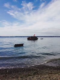 Damage house sinking in sea against sky