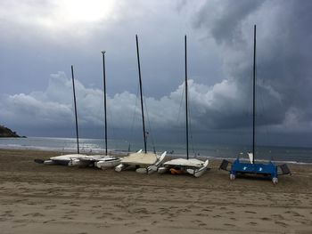 Sailboats on beach against sky