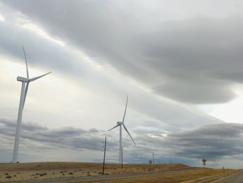 Windmills on field against sky