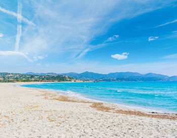 Scenic view of beach against blue sky