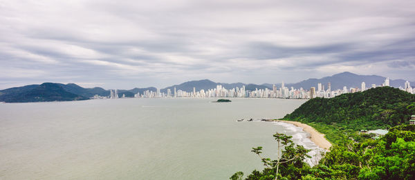 Panoramic view of city against cloudy sky