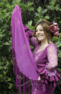 Happy woman in costume standing by plants