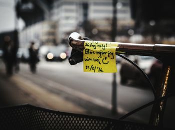 Close-up of reminder note on cropped bicycle handle