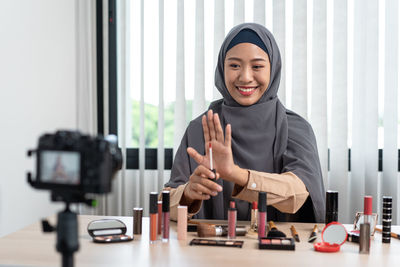 Portrait of young woman using mobile phone at home
