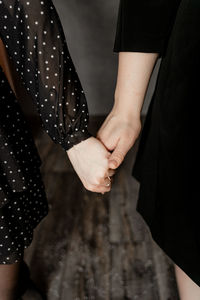 Cropped image of women holding hands