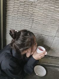 High angle view of woman holding coffee cup at cafe