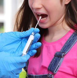 Cropped hand of scientist examining girl