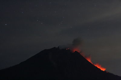 Scenic view of volcanic mountain against sky at night