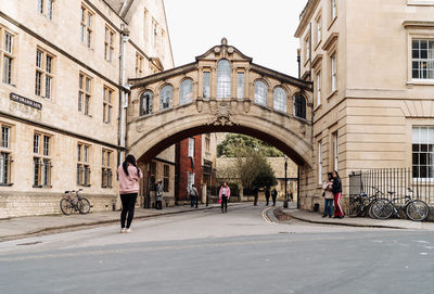 People walking on street amidst buildings in city