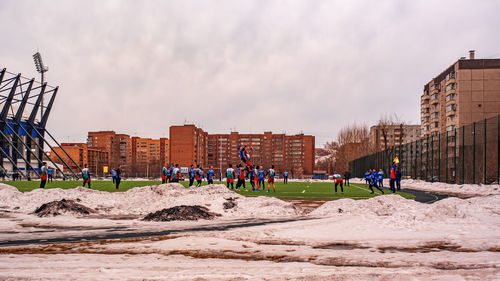 People in court against buildings and sky