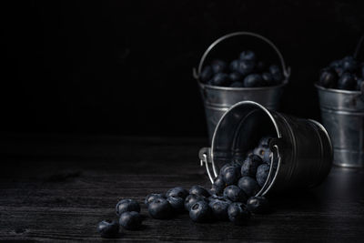 Close-up of grapes in container on table against black background