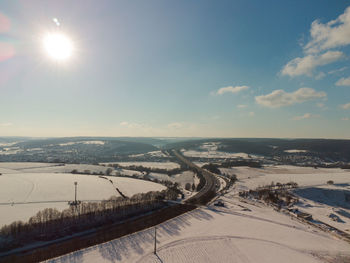 Aerial view of snowcapped landscape against sky during winter