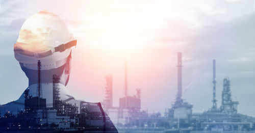 Panoramic view of factory against sky during sunset