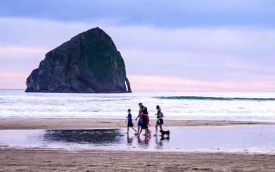 People on beach against sky