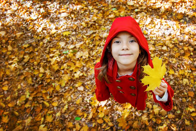 Portrait of girl holding leaf during autumn