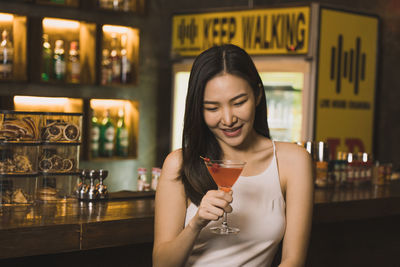 Portrait of young woman using mobile phone in cafe