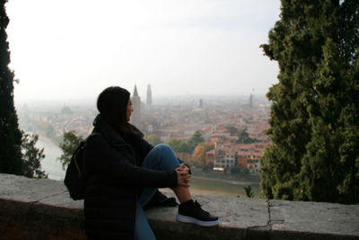 Side view of young woman looking at cityscape