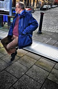 Midsection of man sitting in city