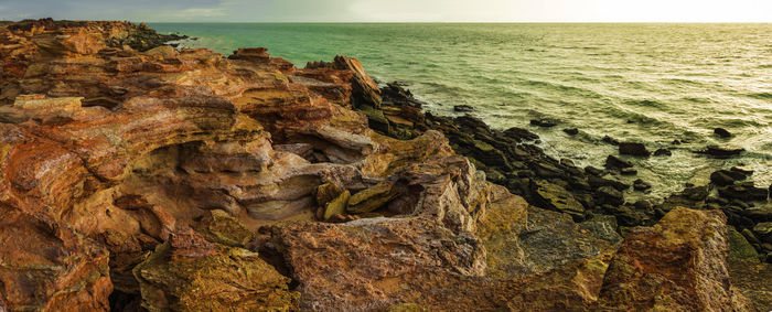 Rock formation in sea against sky