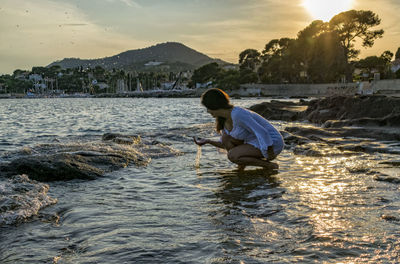 Rear view of boy in sea against sky