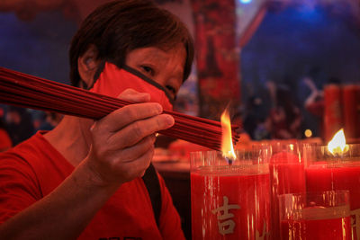 Close-up of woman holding lit candle