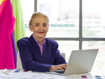 Portrait of smiling woman using smart phone at table