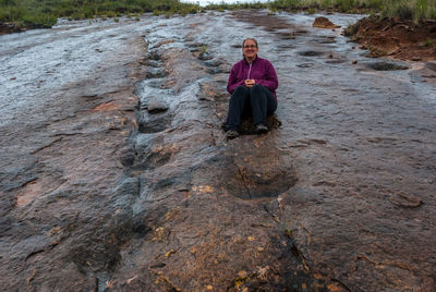 Portrait of woman sitting on rock