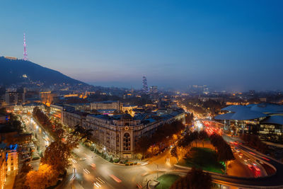 High angle view of illuminated cityscape against sky at night