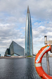 Scenic view of river by buildings against sky