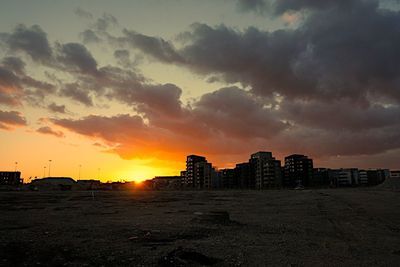 View of cityscape against cloudy sky