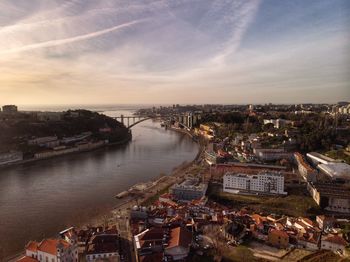 High angle view of river and buildings against sky at sunset