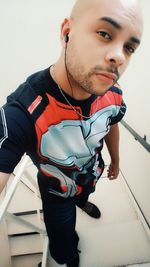 Portrait of young man looking away against wall