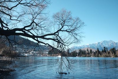 Scenic view of lake by snowcapped mountain against sky