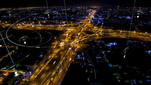 High angle view of city lit up at night