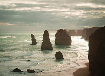 Rocks on sea shore against sky