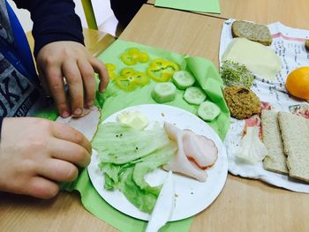 Close-up of hands preparing food at table