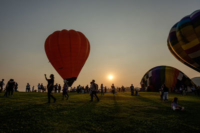 People on field against sky during sunset