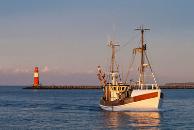 Ship sailing in sea against sky