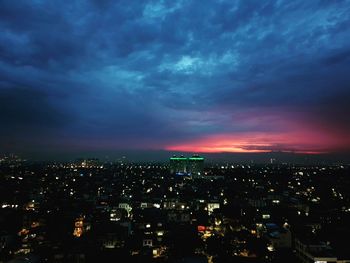 Illuminated buildings in city against sky at night