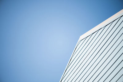 Low angle view of modern building against clear blue sky