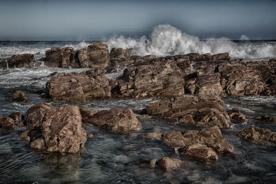 Scenic view of rocks in sea against sky