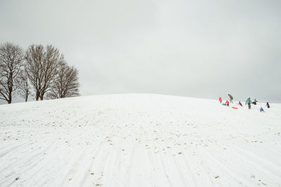 Low angle view of snow covered hill against sky