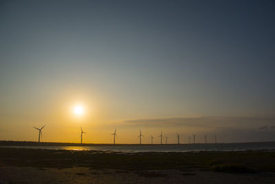 Scenic view of beach against clear sky during sunset