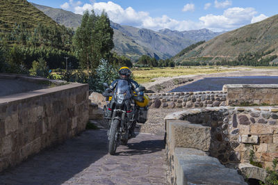 Motorbike driving over a bridge of the urubamba river, peru