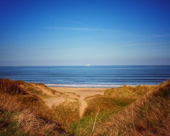 Scenic view of sea against clear blue sky