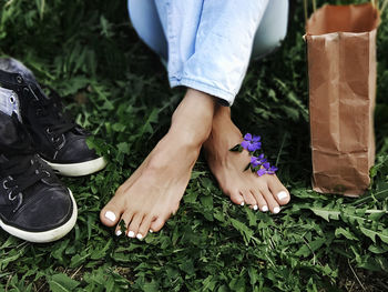 Low section of woman standing on purple flowering plants